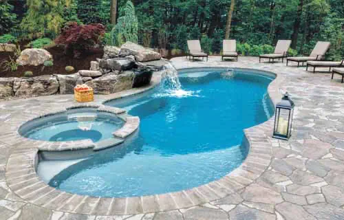 Leisure Pools Allure fiberglass swimming pool with built-in spa and splash deck